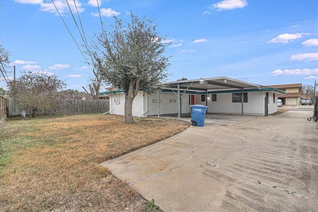 rear view of house with a carport and a yard