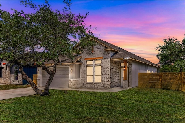 view of front of home with a lawn, brick siding, fence, concrete driveway, and an attached garage