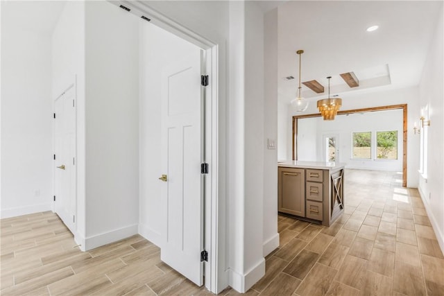 corridor featuring baseboards, recessed lighting, wood finish floors, and an inviting chandelier