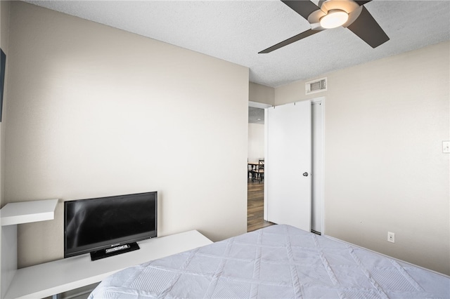 bedroom with a textured ceiling and ceiling fan