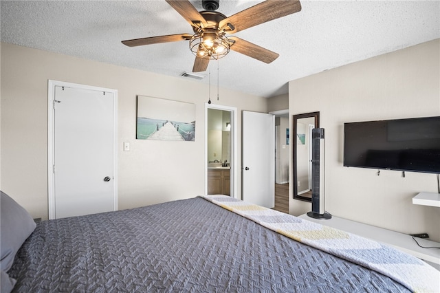 unfurnished bedroom with ensuite bathroom, a textured ceiling, and ceiling fan