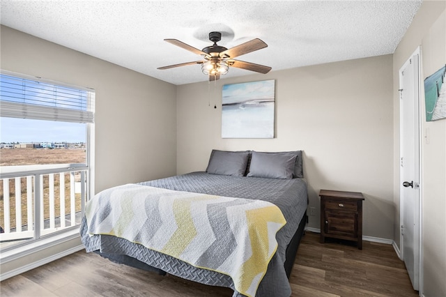 bedroom featuring ceiling fan, dark hardwood / wood-style floors, and a textured ceiling