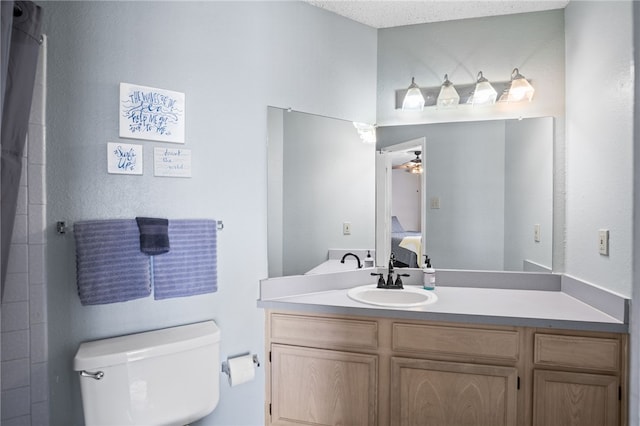 bathroom featuring vanity, a textured ceiling, toilet, and walk in shower