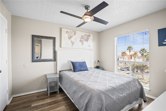 bedroom featuring a textured ceiling, dark wood-type flooring, and ceiling fan