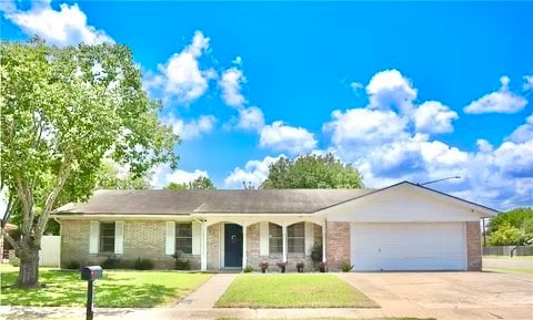 single story home featuring a garage and a front yard