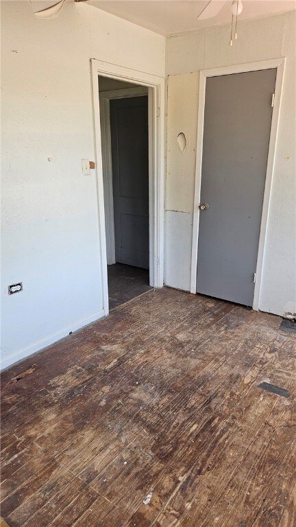 empty room featuring ceiling fan and dark wood-type flooring