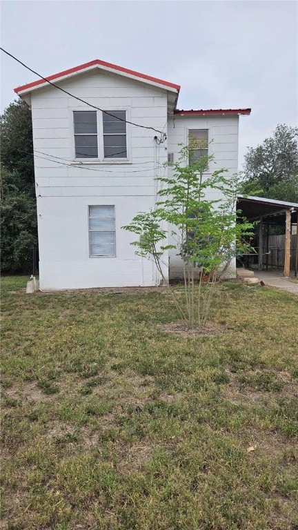 view of home's exterior featuring a carport and a yard