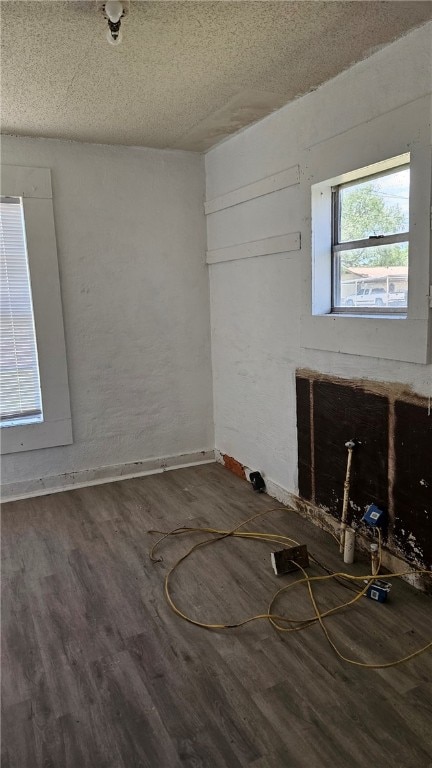 empty room with a textured ceiling and wood finished floors