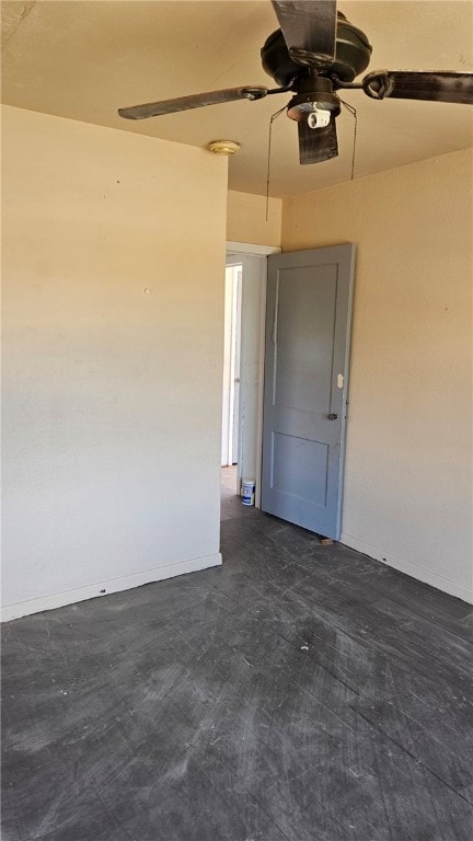 garage featuring baseboards and a ceiling fan