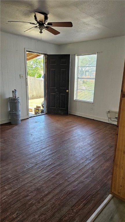 interior space featuring ceiling fan, a textured ceiling, and dark wood-style flooring