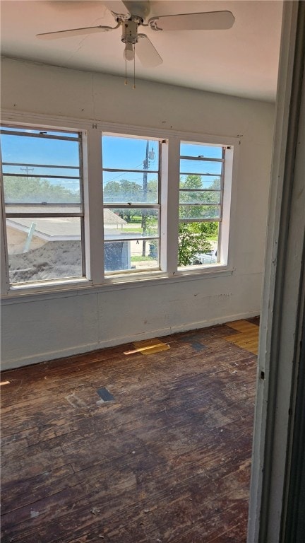 spare room featuring baseboards, ceiling fan, visible vents, and wood finished floors