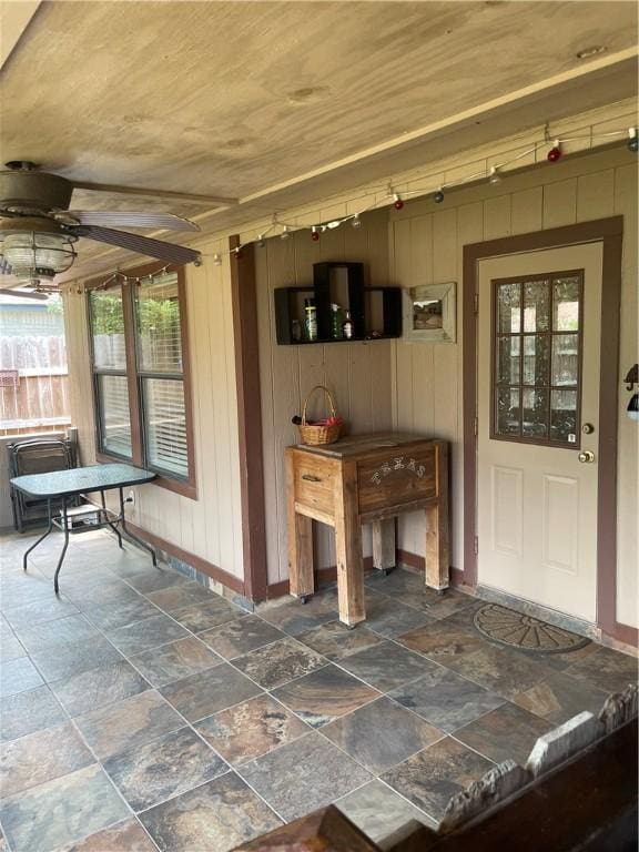 2237 Sunset Cliff Dr, Ingleside, TX 78362 - mudroom featuring baseboards, stone finish floors, a ceiling fan, and wood walls