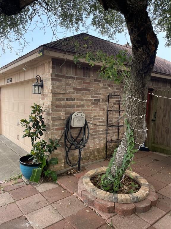 2237 Sunset Cliff Dr, Ingleside, TX 78362 - view of home's exterior with brick siding and roof with shingles