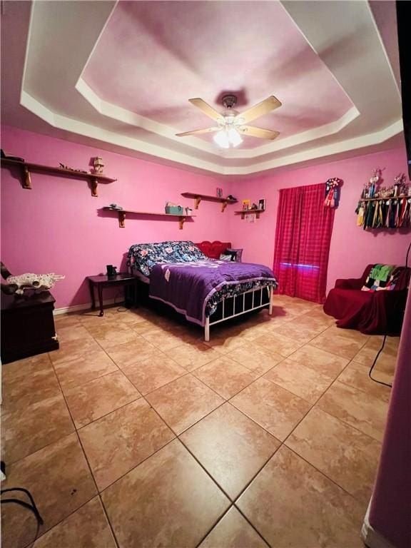 bedroom with a tray ceiling, ceiling fan, and tile patterned flooring