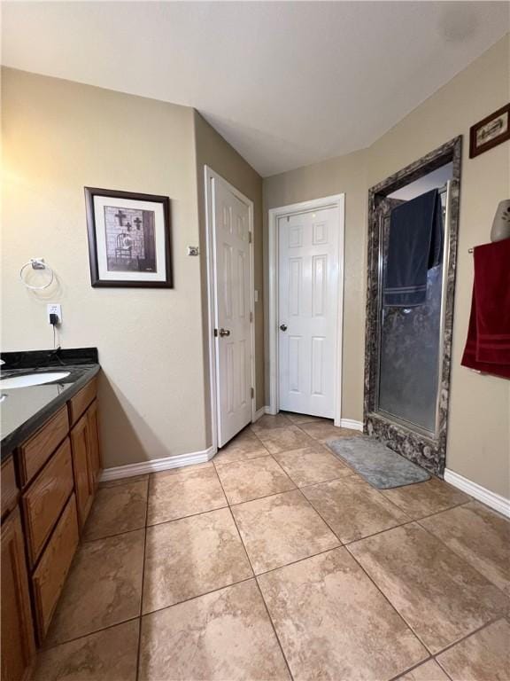 bathroom with a shower, vanity, and tile patterned floors