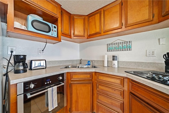 478 S County Road 1144, Riviera, TX 78379 - kitchen with black appliances, light countertops, brown cabinetry, and a textured ceiling