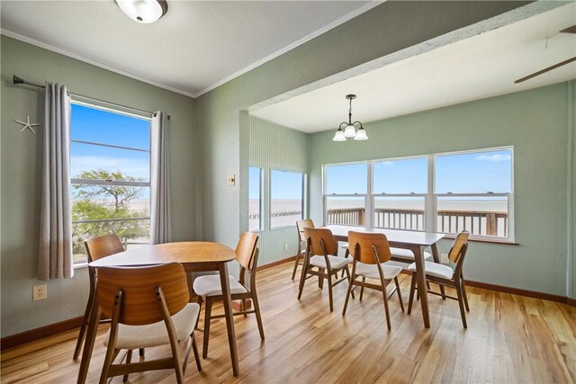 478 S County Road 1144, Riviera, TX 78379 - dining room with baseboards, light wood finished floors, ornamental molding, a chandelier, and a water view