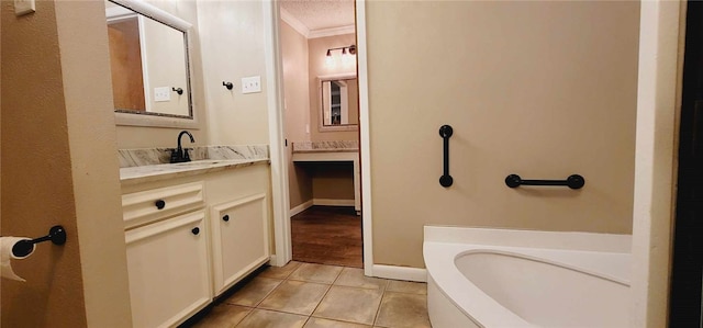 bathroom with vanity, tile patterned floors, a bathtub, and crown molding