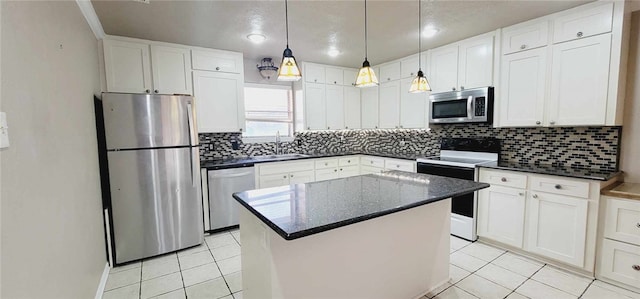 kitchen featuring white cabinets, stainless steel appliances, a kitchen island, and sink