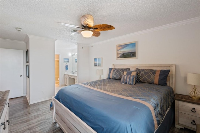 bedroom with baseboards, wood finished floors, a textured ceiling, and crown molding