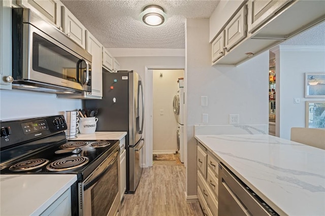 kitchen with crown molding, stainless steel appliances, a textured ceiling, and light wood-style floors