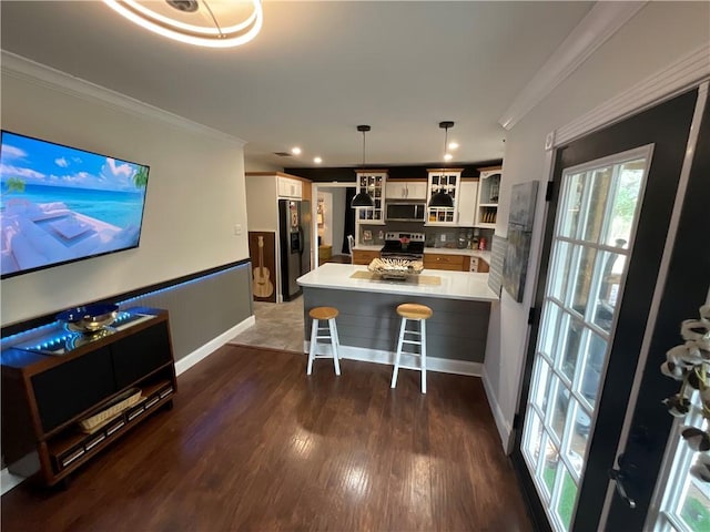 322-342 Whispering Woods Dr, Rockport, TX 78382 - kitchen featuring stainless steel appliances, a peninsula, ornamental molding, glass insert cabinets, and a kitchen bar