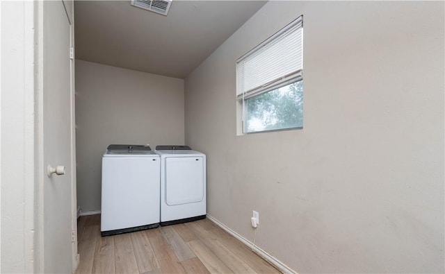 504 E Sarah St, Beeville, TX 78102 - laundry area with washing machine and dryer, light wood-style floors, and baseboards