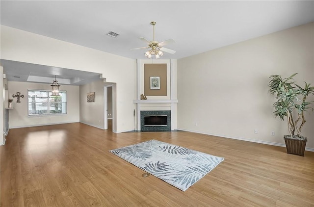 15658 Cumana Dr, Corpus Christi, TX 78418 - unfurnished living room with wood finished floors, ceiling fan, a high end fireplace, and a chandelier
