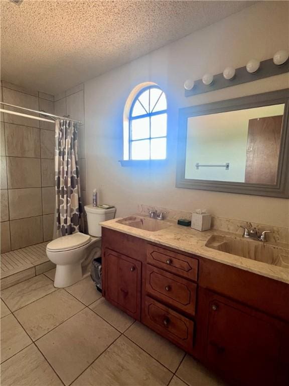 806 Dakota St, Robstown, TX 78380 - bathroom featuring a textured ceiling, double vanity, tiled shower, and tile patterned flooring