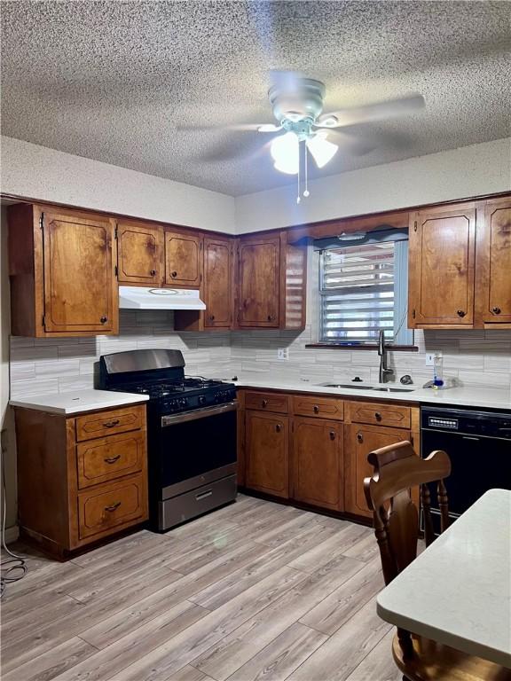 806 Dakota St, Robstown, TX 78380 - kitchen featuring gas range, black dishwasher, brown cabinetry, light countertops, and a textured ceiling