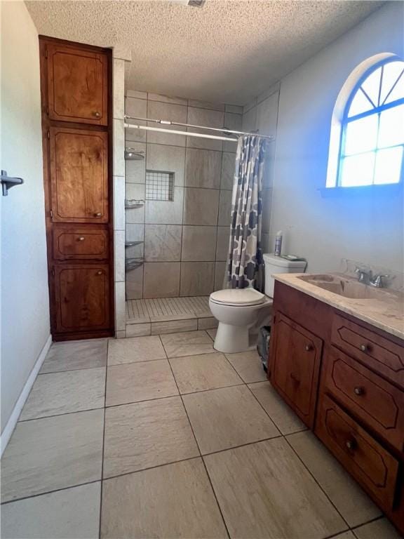 806 Dakota St, Robstown, TX 78380 - bathroom with a textured ceiling, tiled shower, vanity, and tile patterned flooring