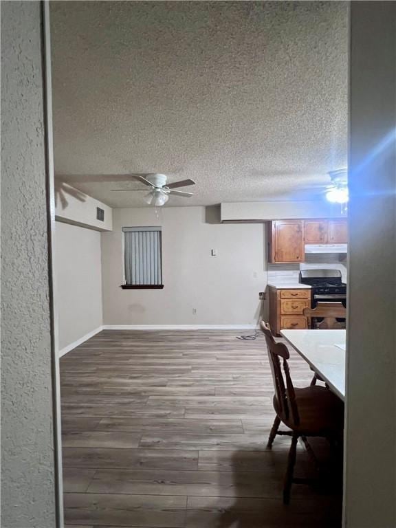 806 Dakota St, Robstown, TX 78380 - unfurnished dining area with ceiling fan, wood finished floors, and a textured ceiling
