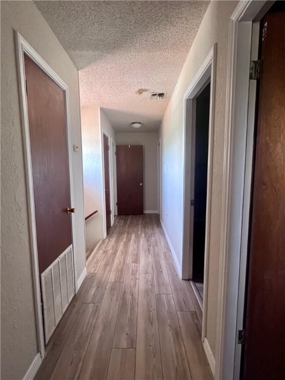 806 Dakota St, Robstown, TX 78380 - hallway with a textured ceiling and wood-type flooring