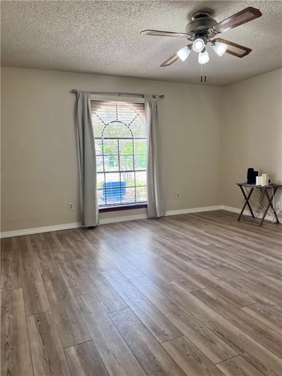 806 Dakota St, Robstown, TX 78380 - spare room featuring a textured ceiling, wood finished floors, and ceiling fan