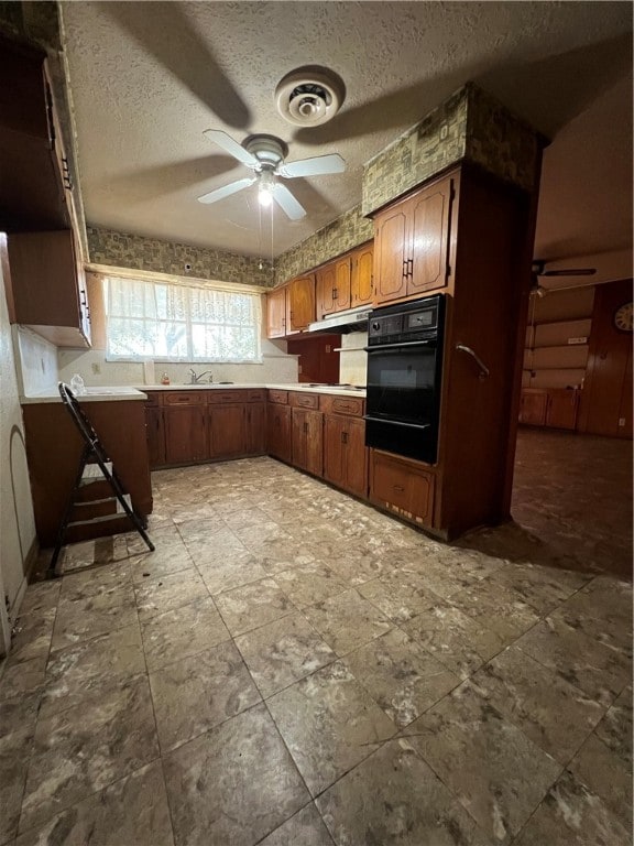 kitchen with black oven, a textured ceiling, and ceiling fan