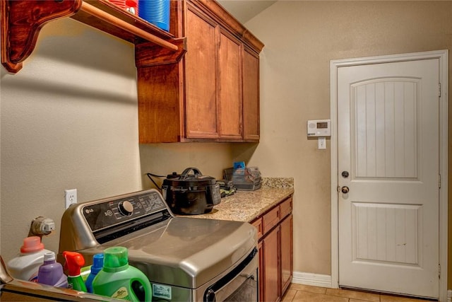 laundry area featuring cabinets and light tile patterned floors