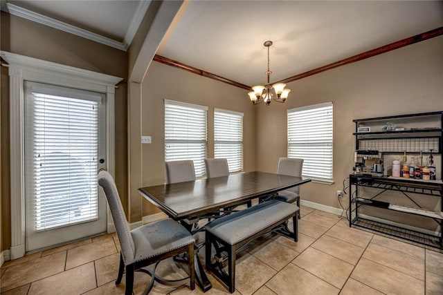 tiled dining area featuring crown molding, a healthy amount of sunlight, and a notable chandelier