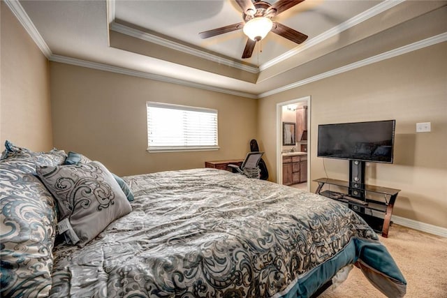 carpeted bedroom featuring ceiling fan, ensuite bathroom, crown molding, and a tray ceiling