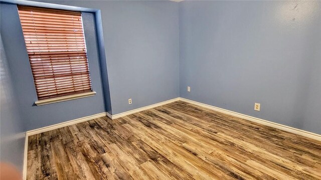 empty room featuring baseboards and wood finished floors