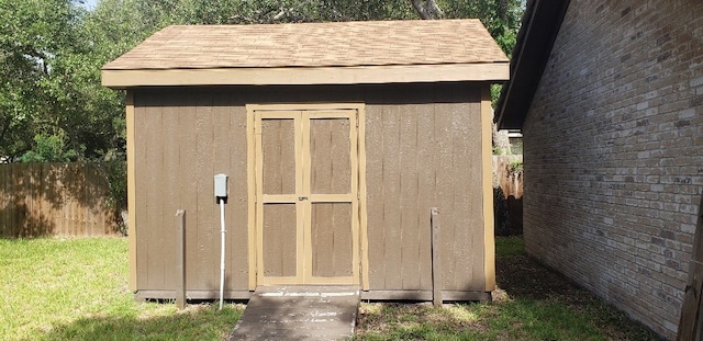 view of shed featuring fence