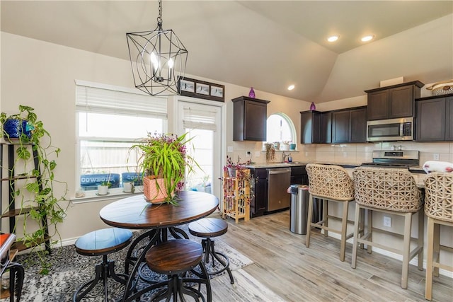 6766 Mikayla St, Corpus Christi, TX 78413 - kitchen with appliances with stainless steel finishes, dark brown cabinets, light wood-style flooring, backsplash, and lofted ceiling