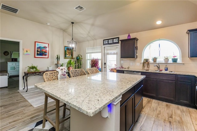 6766 Mikayla St, Corpus Christi, TX 78413 - kitchen with a sink, a kitchen bar, light stone countertops, light wood finished floors, and vaulted ceiling