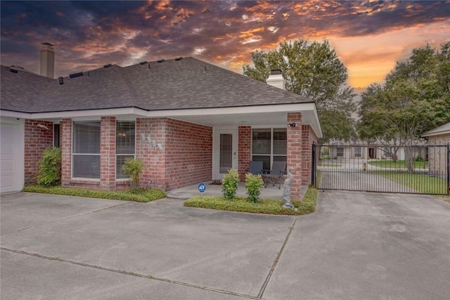 8006 Etienne Dr, Corpus Christi, TX 78414 - view of front facade with a chimney, concrete driveway, a shingled roof, and brick siding