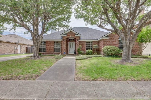 8006 Etienne Dr, Corpus Christi, TX 78414 - view of front of home featuring brick siding, a shingled roof, and a front yard