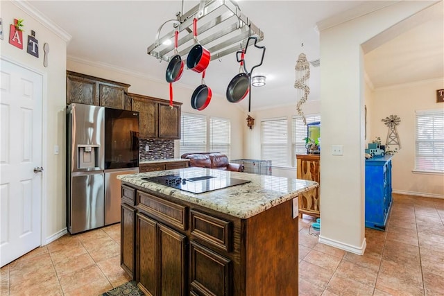 kitchen with black electric stovetop, light tile patterned flooring, stainless steel fridge with ice dispenser, a center island, and crown molding