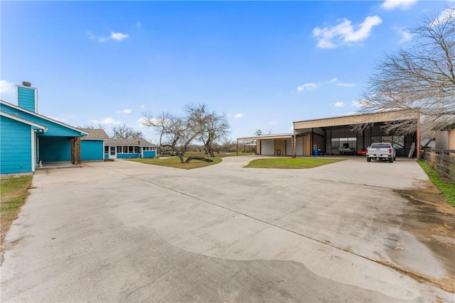 view of side of home with a yard, concrete driveway, and a detached carport