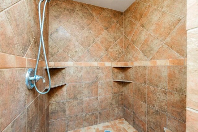 interior details with a tile shower