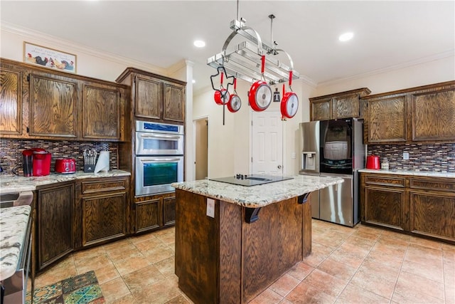 kitchen featuring a kitchen bar, stainless steel appliances, dark brown cabinets, and a center island