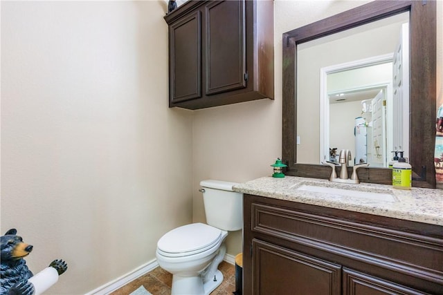 half bathroom featuring vanity, toilet, and baseboards