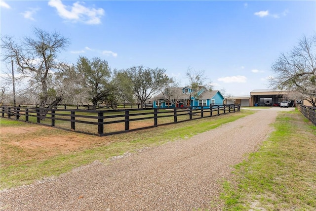 view of street with a rural view and driveway